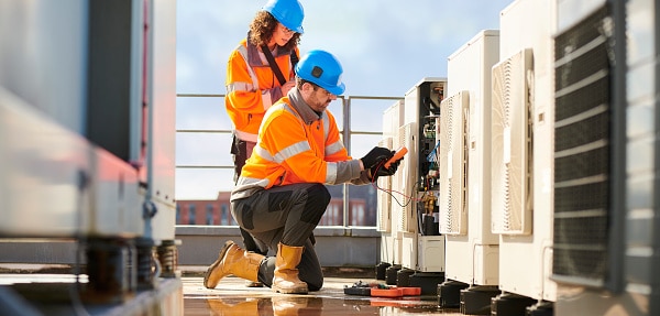 Two Maintenance Workers on roof inspecting HVAC unit